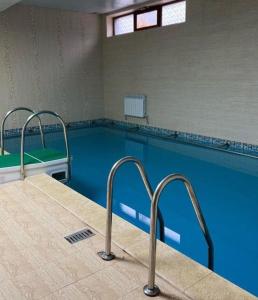 een leeg zwembad met blauw water in een gebouw bij Turgen house in Taūtürgen