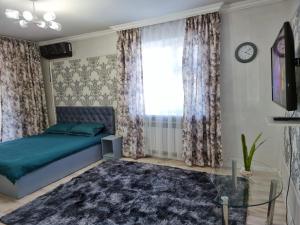 um quarto com uma cama e uma janela em Уютная квартира в хорошем районе Тауке хана em Shymkent