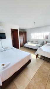 a bedroom with two beds and a flat screen tv at Hotel Sierra Nevada B&B SAS in Valledupar