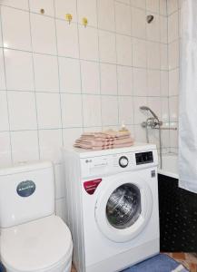 een wasmachine in een badkamer met een toilet bij Уютная квартира в хорошем районе Тауке хана in Simkent