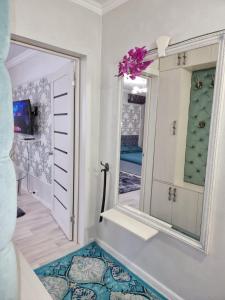 een kamer met een spiegel en een tapijt bij Уютная квартира в хорошем районе Тауке хана in Simkent