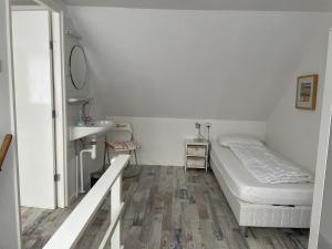 Dormitorio pequeño con cama y lavamanos en De Linden, en Egmond aan Zee