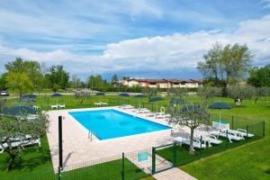 una vista sul soffitto di una piscina con sedie e ombrelloni di Residence Parco a Sirmione