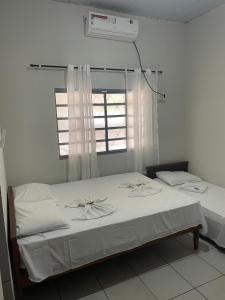uma cama num quarto com uma janela em Pousada Ambiente Familiar em Ponte Alta do Tocantins