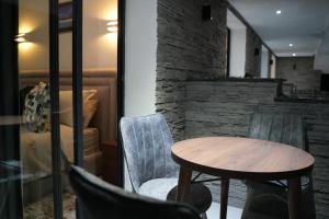 a table and chairs in a room with a stone wall at Le Rocher De L'Atlas in Azrou