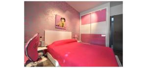 1 dormitorio con cama roja y pared rosa en VILLA CAMPO PREMIUM, en Yecla