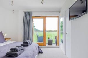 a bedroom with a bed with towels on it at King Bed Joy Lane, Chichester near Goodwood in Chichester