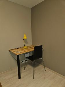 einen Schreibtisch mit einer Lampe und einem Stuhl in einem Zimmer in der Unterkunft Leilighet nær flyplass og Ålesund sentrum in Ytterland