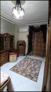 een woonkamer met een tapijt op de vloer bij شقة مفروشة فاخرة بأرقى مواقع المنصورة in Mît Khamîs