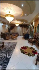 ein großes Wohnzimmer mit einem Sofa und einem Kronleuchter in der Unterkunft شقة مفروشة فاخرة بأرقى مواقع المنصورة in Mît Khamîs