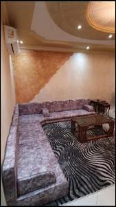 een woonkamer met een bank en een tafel op een tapijt bij شقة مفروشة فاخرة بأرقى مواقع المنصورة in Mît Khamîs