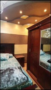 een slaapkamer met een bed, een dressoir en een spiegel bij شقة مفروشة فاخرة بأرقى مواقع المنصورة in Mît Khamîs