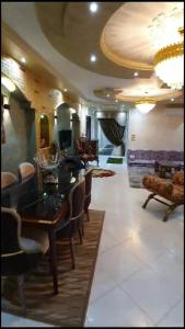 een woonkamer met een eettafel en stoelen bij شقة مفروشة فاخرة بأرقى مواقع المنصورة in Mît Khamîs