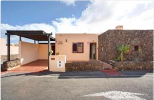 une petite maison avec un mur en pierre dans l'établissement Villa Amistad, à La Oliva