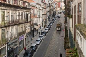 tramwaj na ulicy miejskiej z zaparkowanymi samochodami w obiekcie OPorto Together to 4 people w Porto