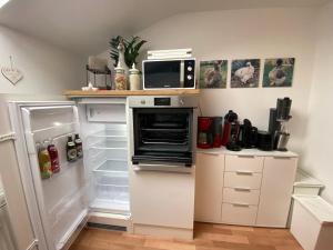 a kitchen with an open refrigerator and a microwave at Ferienwohnung Seidenhuhn in Kiefersfelden +28 photos