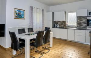 een keuken met een witte tafel en zwarte stoelen bij Awesome Home In Rukavac With Wi-fi in Rukavac