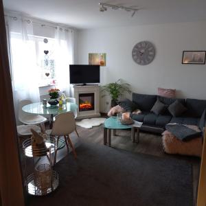 sala de estar con sofá azul y chimenea en Ferienwohnung Weinand, en Birresborn