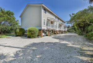 ein großes Haus mit Balkon auf einer Kieseinfahrt in der Unterkunft LAKE PALMS 1 in Sanibel