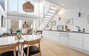 eine Küche und ein Wohnzimmer mit weißen Schränken und einem Tisch in der Unterkunft Beautiful Apartment In Helsingr With Wifi in Helsingør