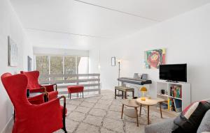 赫爾辛格的住宿－Beautiful Apartment In Helsingr With Wifi，客厅配有红色椅子和钢琴