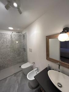 een badkamer met een toilet, een wastafel en een spiegel bij Splendido Loft Centro Storico Parma in Parma