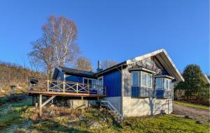 a blue house sitting on top of a grass field at Nice Home In Uddevalla With Kitchen in Sundsandvik