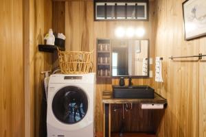 een wasmachine in een badkamer met een wastafel bij Ryunohara Hatago in Tanabe