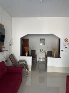 - un salon avec un canapé et des fauteuils rouges dans l'établissement Pousada Ambiente Familiar, à Ponte Alta do Tocantins