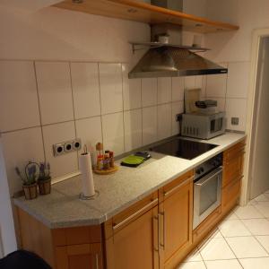 een keuken met een fornuis en een magnetron bij Ferienwohnung Weinand in Birresborn