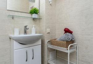 - Baño con lavabo y cesta de toallas en Квартира студия 1 комнатная на Теремках низкий этаж, en Kiev