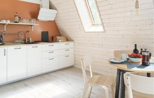 eine Küche mit weißen Schränken und einem Tisch in der Unterkunft Lovely Apartment In Tlen With Kitchen in Tleń