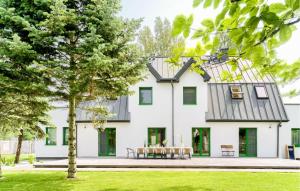 una casa con porte verdi e un tavolo davanti di Lovely Apartment In Tlen With Kitchen a Tleń