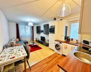 a kitchen and a living room with a table at Relax Apartment 2 in Sighişoara