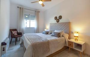 a bedroom with a large bed and a chair at Beautiful Apartment In Torrox in Torrox +7 photos