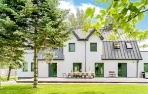 a white house with a table in front of it at Cozy Apartment In Tlen With Kitchen in Tleń