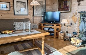 ein Wohnzimmer mit einem TV und einem Tisch in der Unterkunft 3 Bedroom Gorgeous Home In Bykle in Bykle
