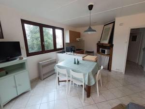 uma cozinha e sala de jantar com mesa e cadeiras em Le Refuge Martin em Les Mazures