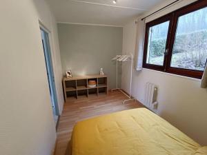 um quarto com uma cama, uma secretária e uma janela em Le Refuge Martin em Les Mazures