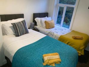 two beds in a room with a window at Averill Street Guest house in Manchester