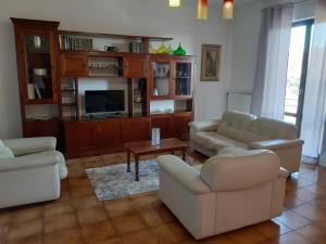 - un salon avec des canapés et une télévision dans l'établissement Casa del Sole, à Pitigliano