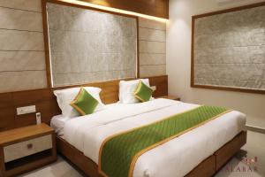 sypialnia z dużym łóżkiem z zielonymi i białymi poduszkami w obiekcie LUXIE INN MALABAR w mieście Perintalmanna