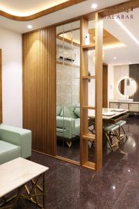 a conference room with a table and green chairs at LUXIE INN MALABAR in Perintalmanna