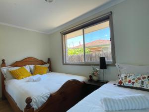 1 dormitorio con 2 camas y ventana en YF Hostel, en Craigieburn