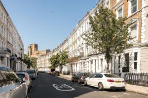 a city street with cars parked on the side of the road at Marvellous Flat in Earls Court in London