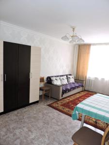 a bedroom with a bed and a cabinet in it at NBG Flat in Almaty