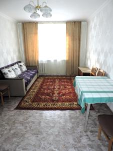 a living room with a couch and a table at NBG Flat in Almaty