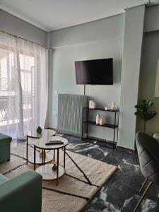 a living room with a couch and a tv at Olivia Apartment-Private parking in Chalkida