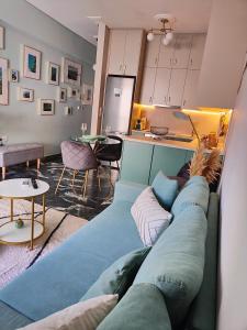 a living room with a blue couch and a kitchen at Olivia Apartment-Private parking in Chalkida