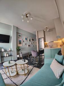 uma sala de estar com um sofá azul e uma mesa em Olivia Apartment-Private parking em Chalkida